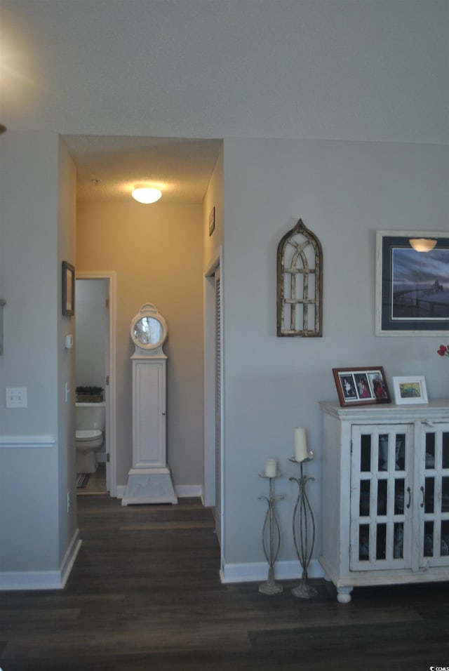 corridor featuring wood finished floors and baseboards