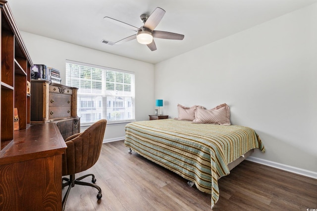 bedroom featuring ceiling fan, baseboards, visible vents, and wood finished floors