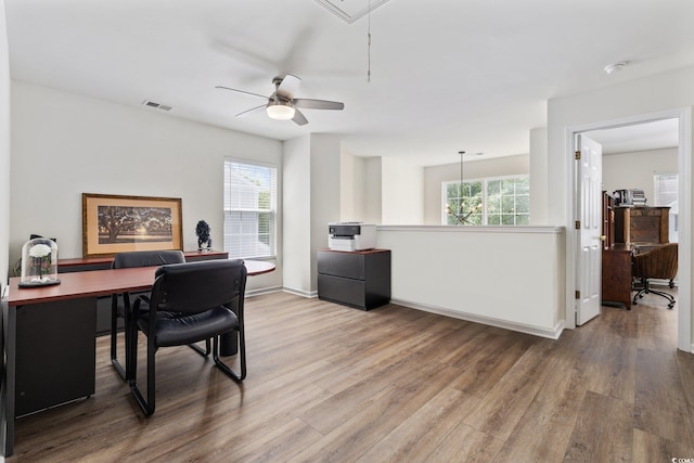 office with attic access, baseboards, ceiling fan, visible vents, and wood finished floors