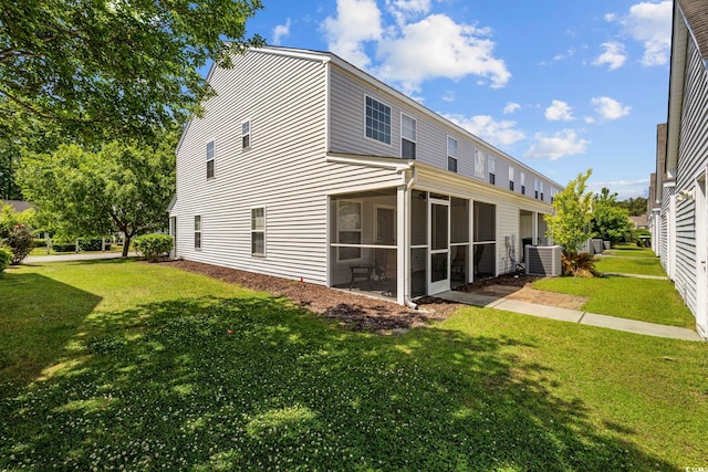 back of house with a sunroom, a lawn, and central air condition unit