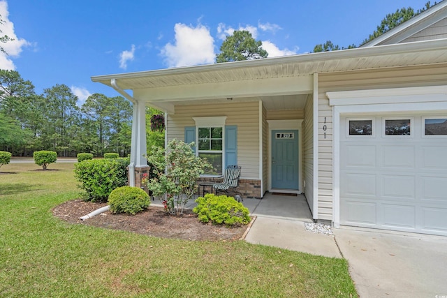 view of exterior entry featuring covered porch, a yard, brick siding, and a garage