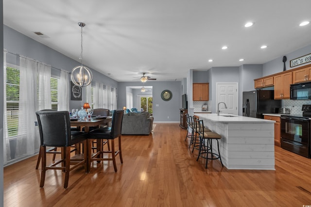 dining area featuring light wood-style flooring, recessed lighting, baseboards, a chandelier, and ceiling fan