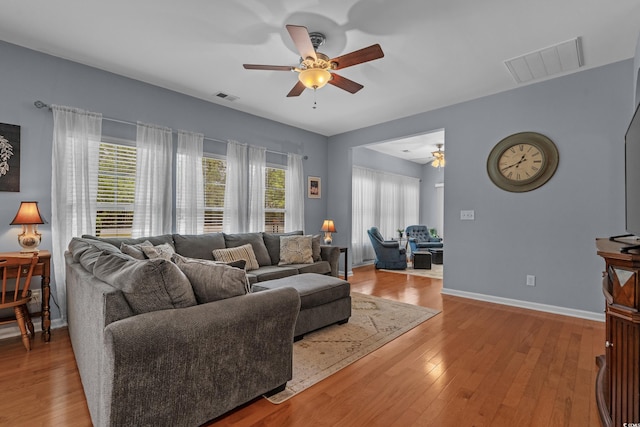 living room featuring ceiling fan, healthy amount of natural light, and wood finished floors