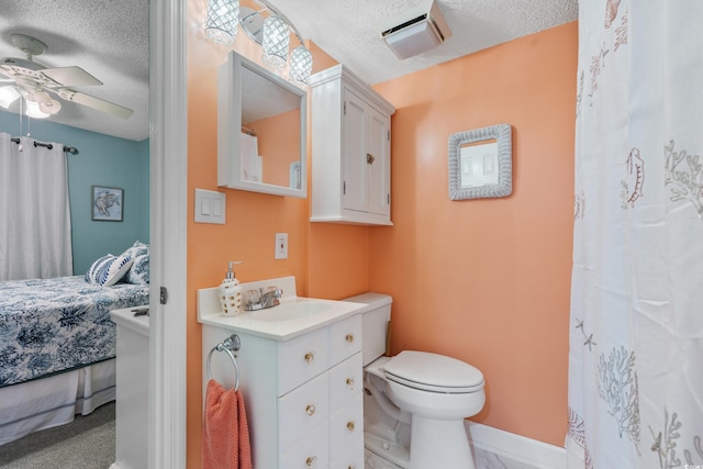 ensuite bathroom featuring vanity, a textured ceiling, toilet, and ceiling fan