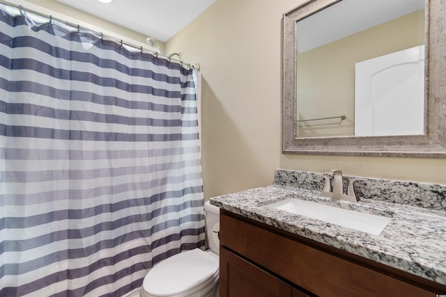 bathroom with toilet, vanity, and curtained shower