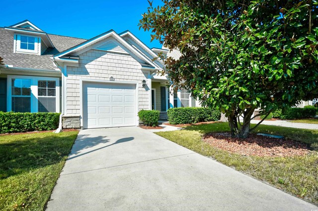 6172 Catalina Dr Unit 214, North Myrtle Beach, SC 29582 - view of front of property with an attached garage, driveway, a shingled roof, and a front yard