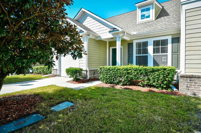6172 Catalina Dr Unit 214, North Myrtle Beach, SC 29582 - view of front of property with a garage, a shingled roof, and a front lawn