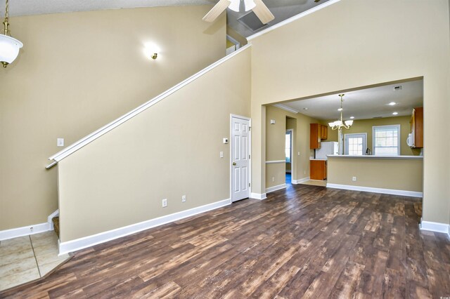6172 Catalina Dr Unit 214, North Myrtle Beach, SC 29582 - unfurnished living room with dark wood finished floors, a chandelier, baseboards, a ceiling fan, and a high ceiling