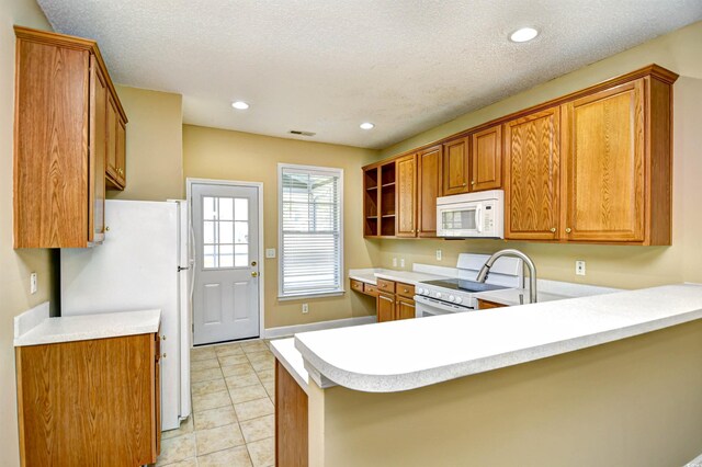 6172 Catalina Dr Unit 214, North Myrtle Beach, SC 29582 - kitchen featuring white appliances, a peninsula, light countertops, brown cabinets, and recessed lighting