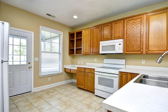 6172 Catalina Dr Unit 214, North Myrtle Beach, SC 29582 - kitchen with white appliances, a sink, light tile patterned flooring, brown cabinetry, and light countertops