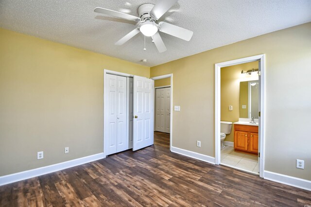 6172 Catalina Dr Unit 214, North Myrtle Beach, SC 29582 - unfurnished bedroom with wood finished floors, baseboards, a closet, a textured ceiling, and connected bathroom