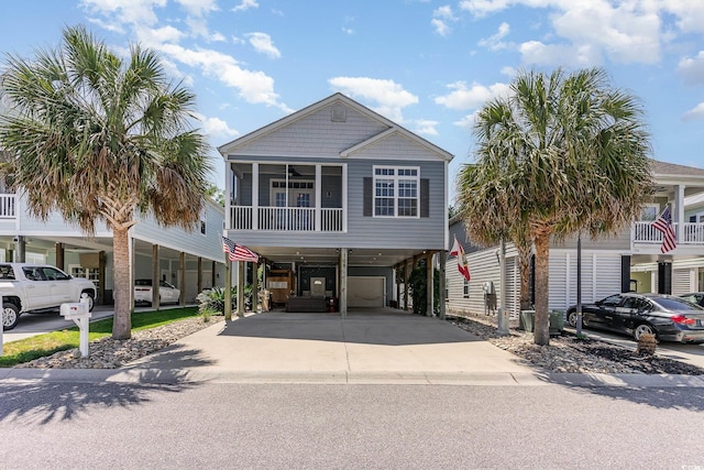 coastal inspired home with driveway, a carport, and a sunroom