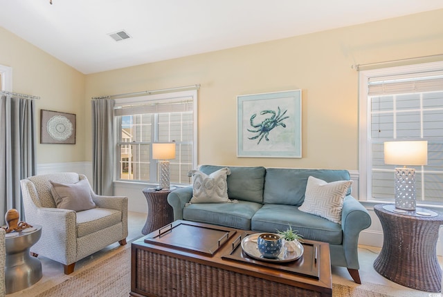 living room with light colored carpet, plenty of natural light, and vaulted ceiling