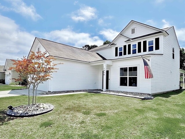 traditional-style home with a garage, driveway, and a front lawn