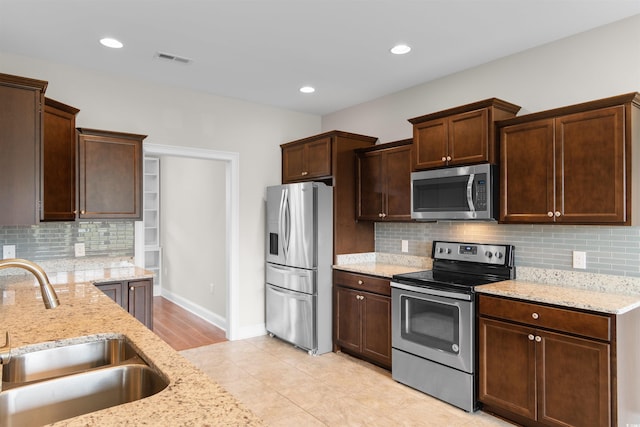 4067 Ridgewood Dr, Conway, SC 29526 - kitchen with appliances with stainless steel finishes, a sink, decorative backsplash, light stone counters, and dark brown cabinets