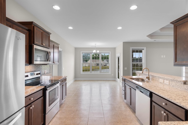 4067 Ridgewood Dr, Conway, SC 29526 - kitchen featuring appliances with stainless steel finishes, a sink, dark brown cabinets, light stone counters, and decorative backsplash