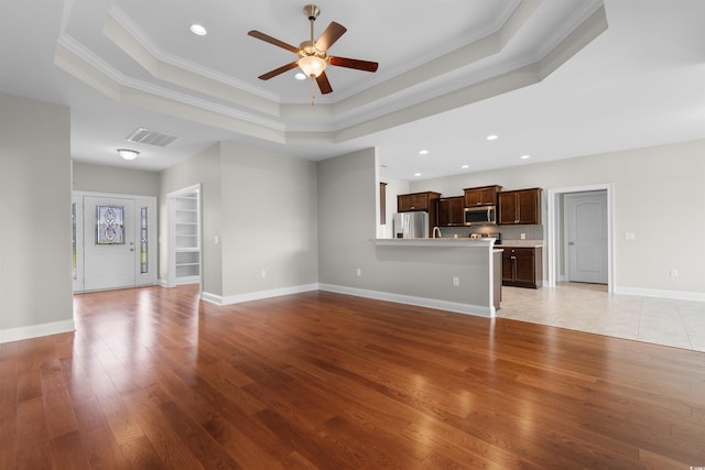 4067 Ridgewood Dr, Conway, SC 29526 - unfurnished living room with a raised ceiling, crown molding, light wood-style flooring, a ceiling fan, and recessed lighting