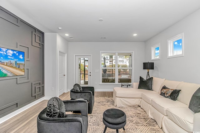living room with recessed lighting, light wood-style floors, and visible vents