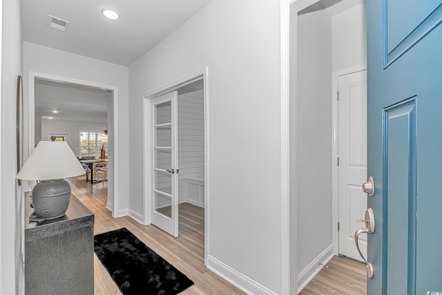 hall with baseboards and light wood-style floors
