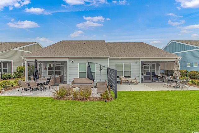 rear view of house with a yard, a sunroom, and a patio area