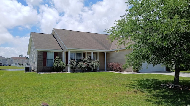 view of front of house featuring central AC unit, driveway, a garage, and a front yard