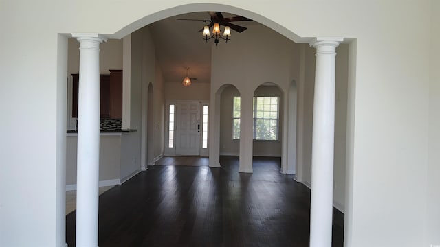 foyer featuring dark wood-style flooring, arched walkways, a ceiling fan, and baseboards