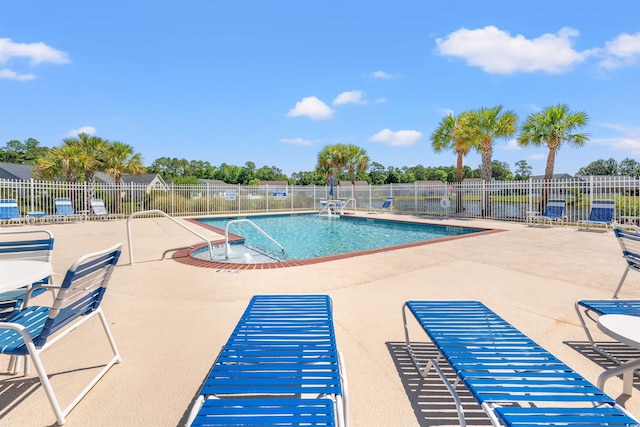 community pool featuring fence and a patio area