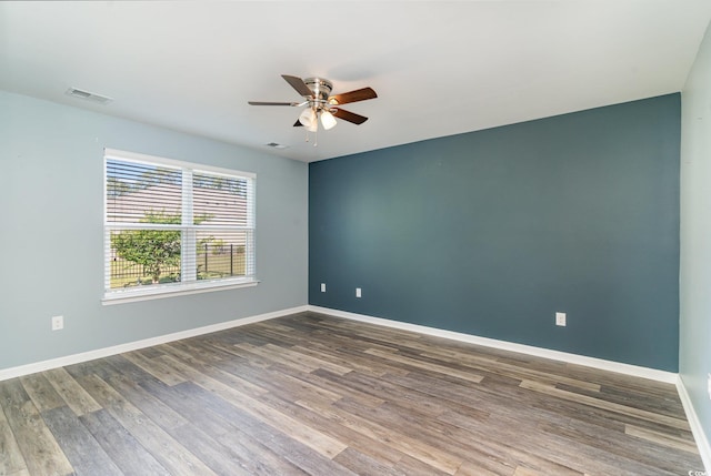unfurnished room with a ceiling fan, wood finished floors, and baseboards
