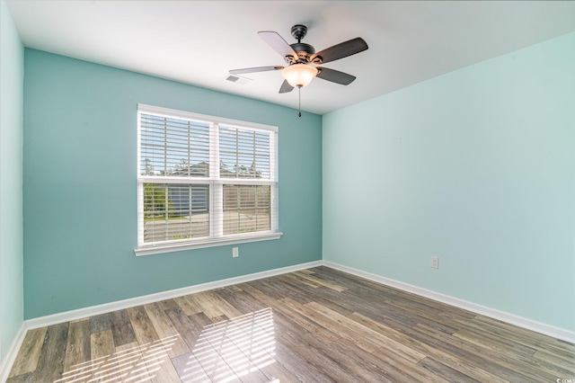 empty room with ceiling fan, wood finished floors, and baseboards