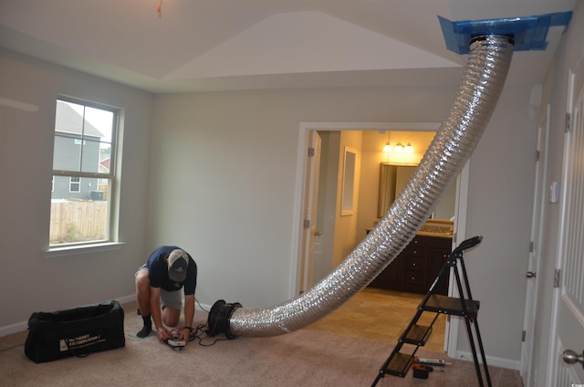 workout room featuring carpet flooring, lofted ceiling, and baseboards