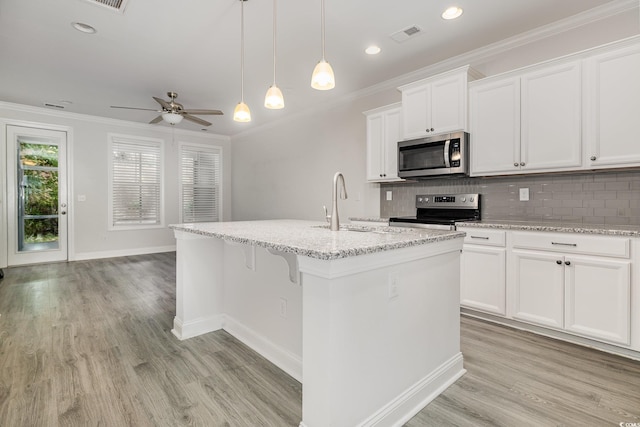kitchen featuring stainless steel appliances, a sink, tasteful backsplash, light wood-type flooring, and baseboards