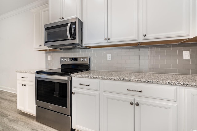 kitchen with stainless steel appliances, light wood-style floors, white cabinets, and tasteful backsplash
