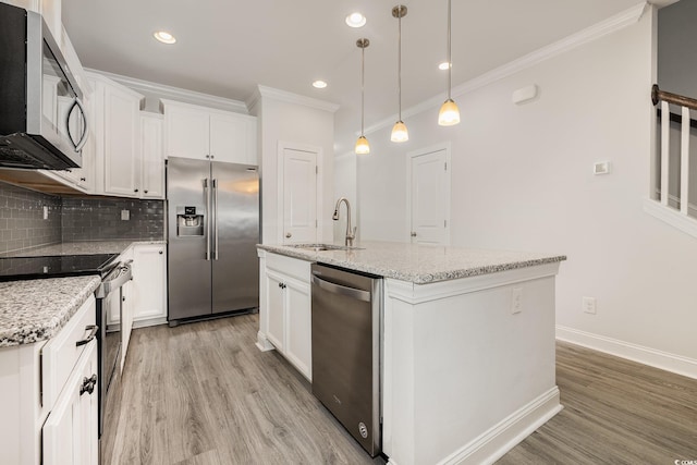 kitchen featuring stainless steel appliances, a sink, crown molding, light wood finished floors, and backsplash