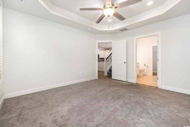 unfurnished bedroom featuring ornamental molding, a raised ceiling, carpet floors, recessed lighting, and baseboards