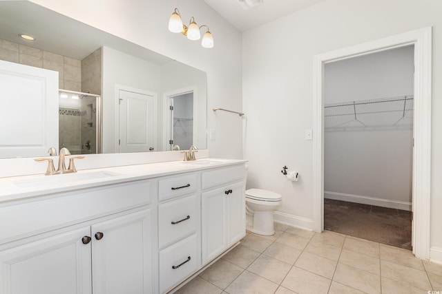 bathroom featuring a shower stall, double vanity, tile patterned floors, baseboards, and toilet