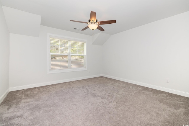 carpeted spare room featuring ceiling fan and baseboards