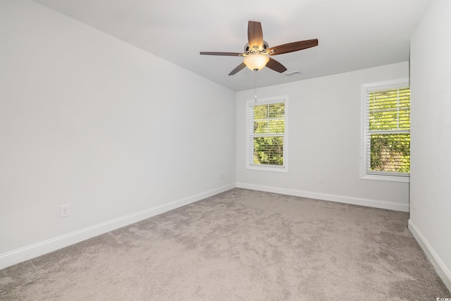 carpeted empty room with baseboards and a ceiling fan