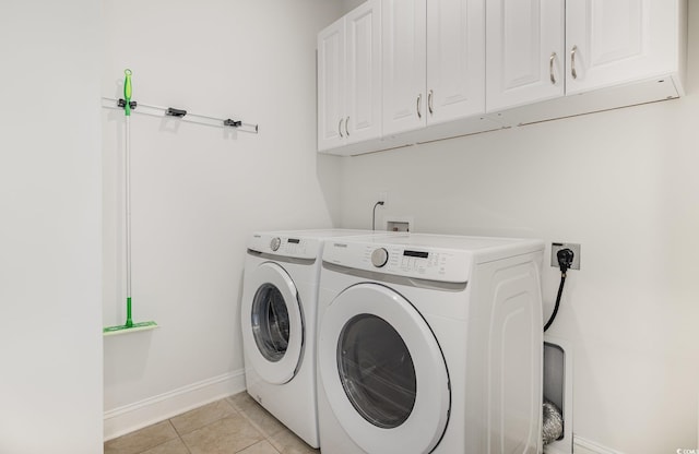 washroom featuring cabinet space, independent washer and dryer, baseboards, and light tile patterned flooring
