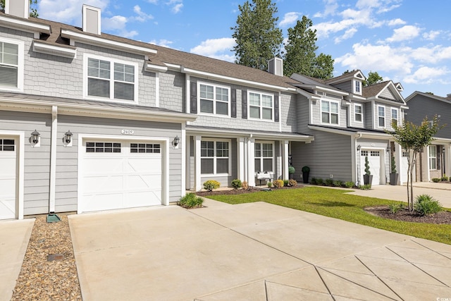 view of front facade with a chimney, concrete driveway, an attached garage, a residential view, and roof with shingles