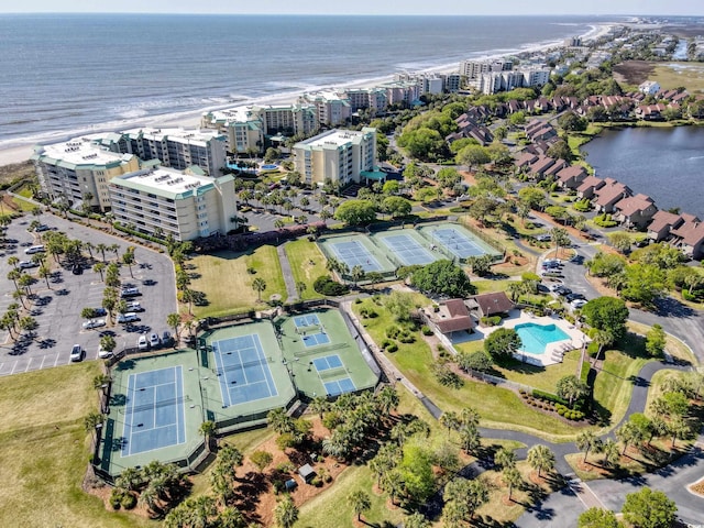aerial view of property and surrounding area with a nearby body of water, a pool, and nearby urban area