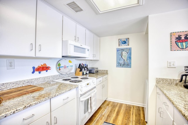 kitchen with white appliances, light wood finished floors, white cabinetry, baseboards, and light stone counters