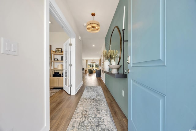 interior space featuring french doors, a chandelier, and wood finished floors