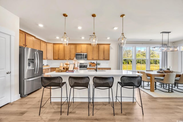 402 Sun Colony Blvd, Longs, SC 29568 - kitchen with appliances with stainless steel finishes, light countertops, recessed lighting, a kitchen breakfast bar, and light wood-style floors