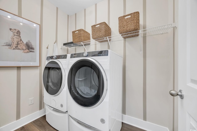 washroom with baseboards, dark wood finished floors, laundry area, and washer and clothes dryer