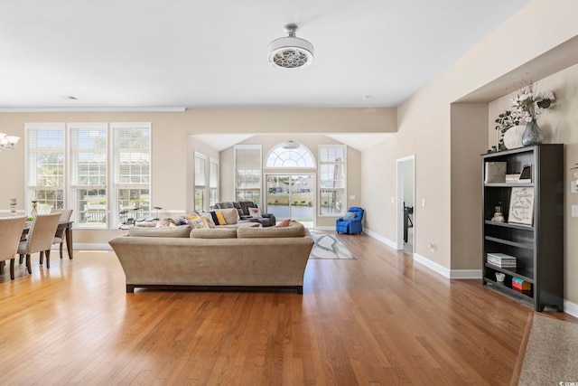 living room featuring an inviting chandelier, wood finished floors, and baseboards