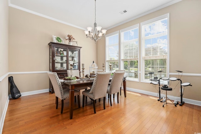 dining area featuring crown molding, a notable chandelier, baseboards, and visible vents