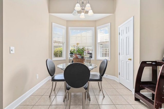 dining area featuring light tile patterned floors, baseboards, and a notable chandelier