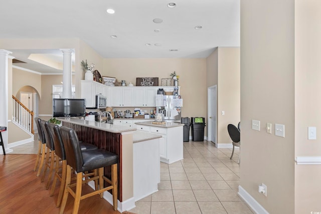 886 Carolina Farms Blvd, Myrtle Beach, SC 29579 - kitchen with ornate columns, a peninsula, baseboards, a center island, and white cabinetry