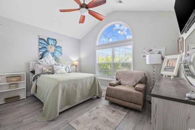 bedroom featuring baseboards, visible vents, ceiling fan, vaulted ceiling, and wood finished floors