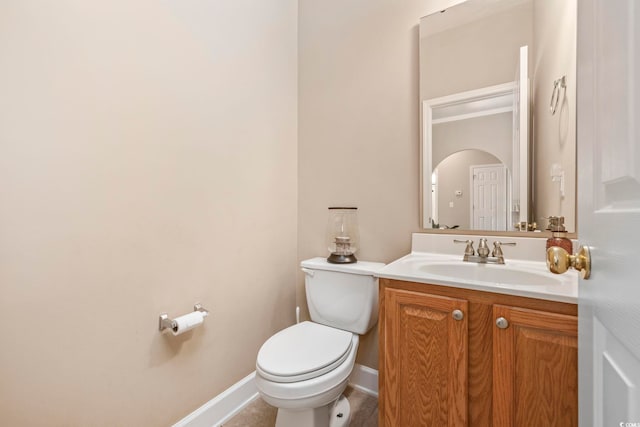 bathroom with vanity, toilet, and baseboards